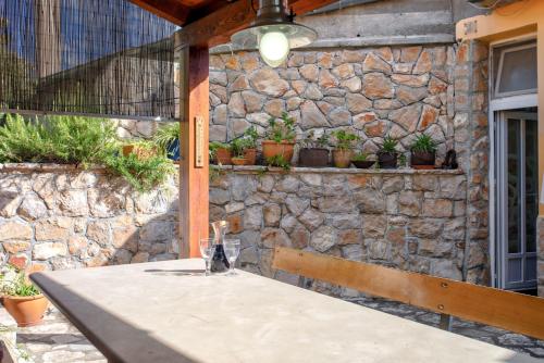 a stone wall with a table in front of a building at Villa Cincilograd in Jelsa