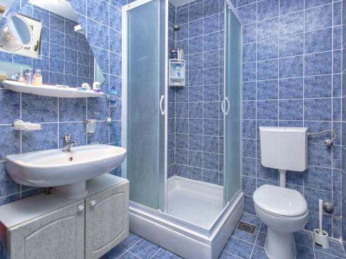 a blue tiled bathroom with a toilet and a sink at Villa Cincilograd in Jelsa