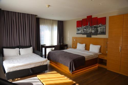 Habitación de hotel con 2 camas y escritorio en Endless Suites Taksim, en Estambul