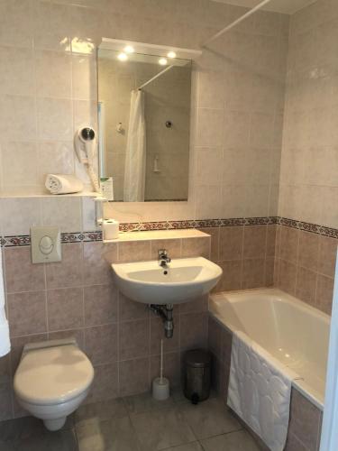 une salle de bain avec un lavabo, des toilettes et une baignoire dans l'établissement Citronnier Monaco Sea View, à Beausoleil