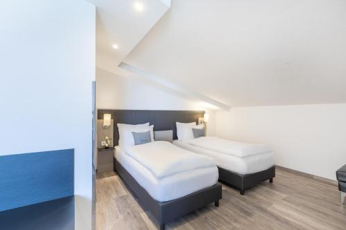 a hotel room with two beds and a table at Select Hotel A1 Bremen-Stuhr in Stuhr