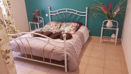 1 dormitorio con cama de metal y pared verde en Gites de Madame en Escazeaux