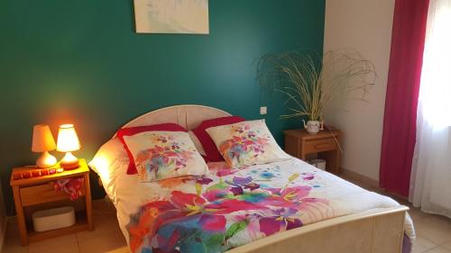 a bedroom with a bed with colorful sheets and pillows at Gites de Madame in Escazeaux