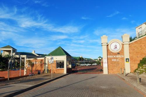 a building with a clock on the side of it at First Group Brookes Hill Suites in Summerstrand