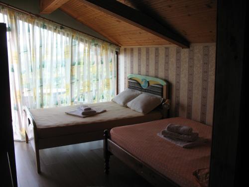 a small bedroom with two beds and a window at Guest House Slivek in Slivek