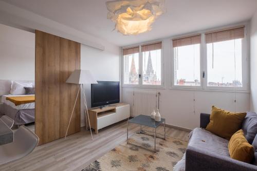 a living room with a couch and a bed at HONORÊ SUITE SAINT ANTOINE in Lyon