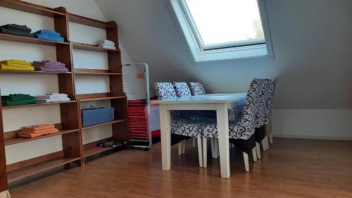 a table and chairs in a room with a shelf at Vakantiehuis Horsterwold in Zeewolde