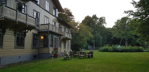 un patio con mesa y sillas junto a un edificio en Mössebergs vandrarhem en Falköping