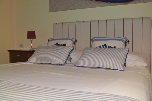 a bed with two blue and white pillows on it at Apartamento en Casco Histórico in San Sebastián de la Gomera