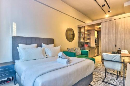 ein Schlafzimmer mit einem großen Bett und einem grünen Stuhl in der Unterkunft Luxurious Designer Gem located at The Harri in Kapstadt