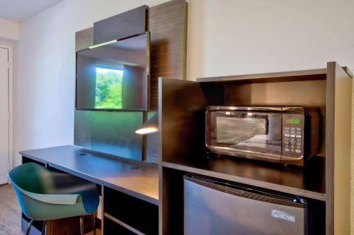 a kitchen with a counter with a microwave and a table at Motel 6-Warren, MI - Detroit East in Warren