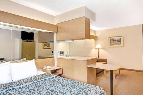 ein Hotelzimmer mit einem Bett und einer kleinen Küche in der Unterkunft Days Inn by Wyndham Sturbridge in Sturbridge