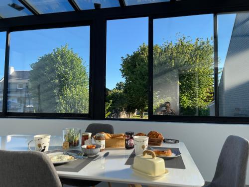 - une table avec de la nourriture dans une chambre avec des fenêtres dans l'établissement Da Gousket, à Étel