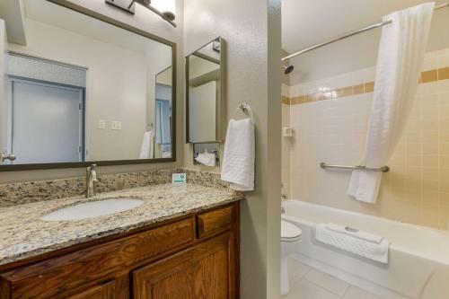 a bathroom with a sink and a tub and a toilet at Best Western Pecos Inn in Artesia