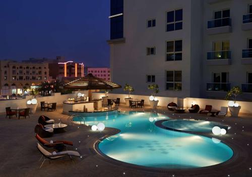 a swimming pool in the middle of a hotel at night at Hyatt Place Dubai Al Rigga in Dubai