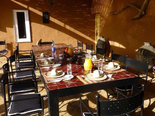 a long table with chairs and plates on it at Le Palais Mandarine in Taroudant