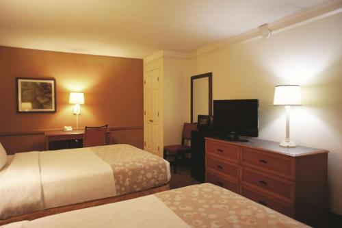a hotel room with two beds and a flat screen tv at Days Inn by Wyndham Augusta Washington Rd in Augusta
