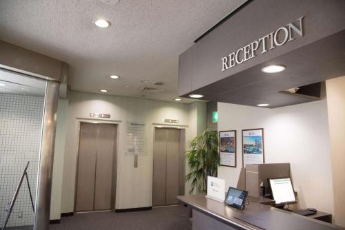 an office lobby with a reception desk and elevators at Best Western Osaka Tsukamoto in Osaka