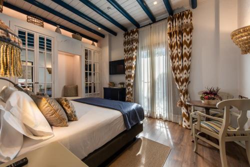 a bedroom with a bed and a table and a chair at Hotel La Malvasía in El Rocío