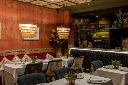 a restaurant with tables and chairs and a bar at Hotel La Malvasía in El Rocío