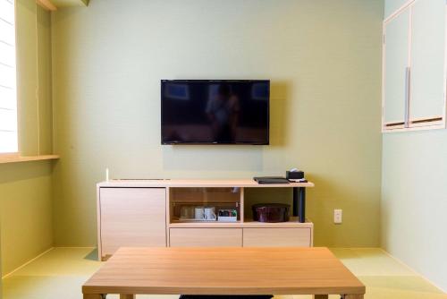 a living room with a tv on a wall at Best Western Plus Hotel Fino Chitose in Chitose