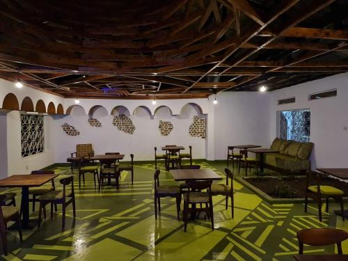 a room with tables and chairs on a green floor at GKAT Resort in Mbarara