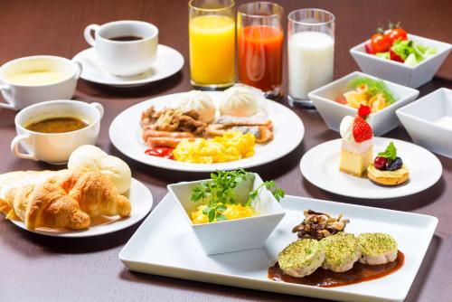 a table with plates of breakfast foods and drinks at Best Western Plus Hotel Fino Chitose in Chitose