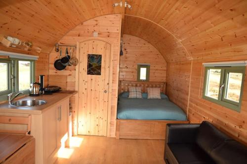 una camera da letto in una baita di tronchi con un letto in esso di The Hobbit House on the Isle of Skye a Breakish