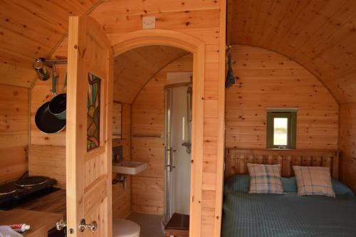 una camera con un letto in una cabina di legno di The Hobbit House on the Isle of Skye a Breakish