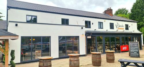 a white building with stools in front of it at The Waterside Bar Rooms & Restaurant in Manchester