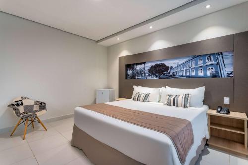 a hotel room with a large bed and a chair at TRYP by Wyndham Manaus Aeroporto in Manaus