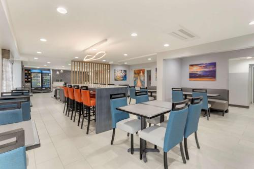 Best Western Plus Cleveland Inn & Suites في كليفلاند: مطعم به طاولات وكراسي وبار