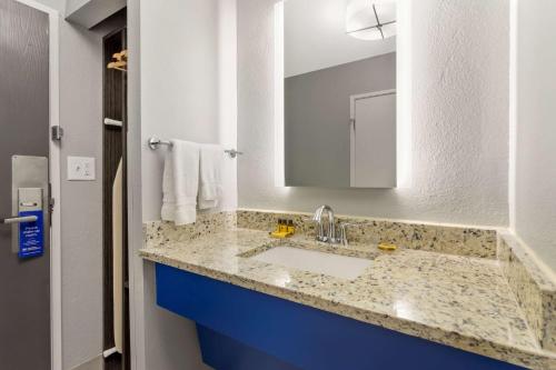 a bathroom with a sink and a mirror at Best Western Plus Magnolia Inn & Suites in Cleveland