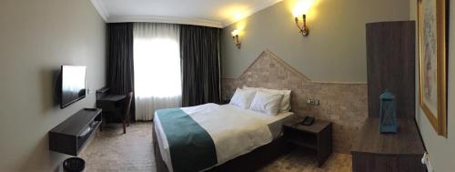 a hotel room with a bed and a window at Grand Park Hotel Corlu in Çorlu