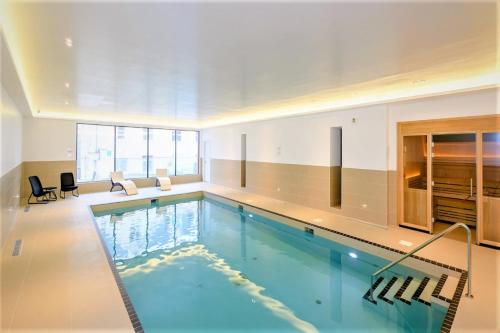 a swimming pool in a large room with a large window at 4 Woolacombe West - Luxury Apartment at Byron Woolacombe, only 4 minute walk to Woolacombe Beach! in Woolacombe