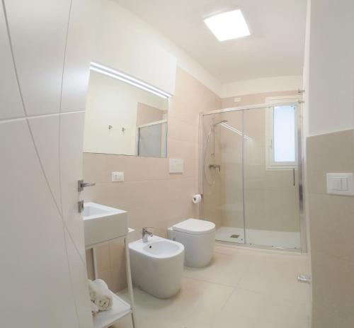 uma casa de banho branca com um WC e um lavatório em Salento- Villa Torricella em Leverano