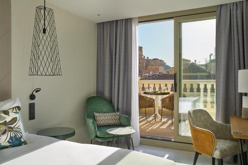 a hotel room with a bed and a view of a balcony at Vincci Larios Diez in Málaga