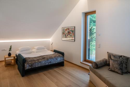 ein Schlafzimmer mit einem Bett und einem Sofa in der Unterkunft steiRerBLiCke - Domizil Vochera am Weinberg mit Pool 