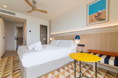 a hotel room with a large bed and a yellow table at Akquaaa Boutique Hotel in Calafell