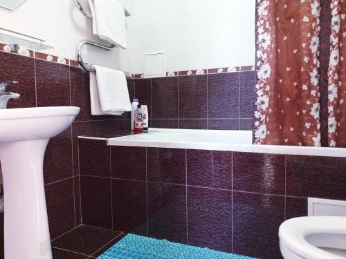 La salle de bains est pourvue d'une baignoire, de toilettes et d'un lavabo. dans l'établissement Plaza Apartments, à Bishkek