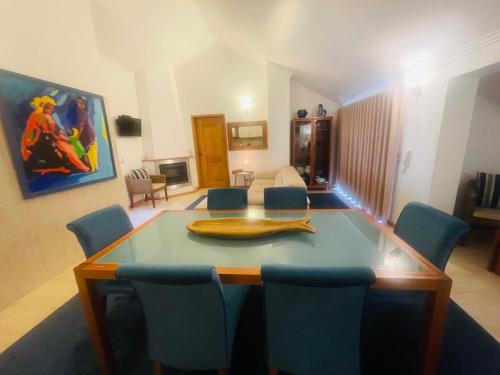 ein Esszimmer mit einem Tisch und blauen Stühlen in der Unterkunft LOCAL-PRESTIGE in Torreira