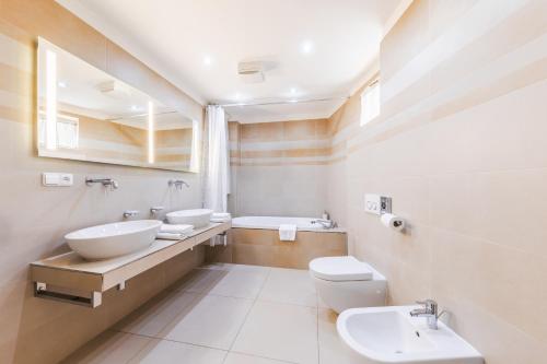 La salle de bains est pourvue de 2 lavabos et de 2 toilettes. dans l'établissement Aparthotel Tycho de Brahe, à Prague