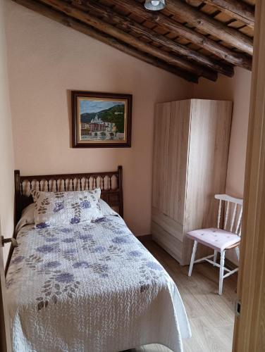 1 dormitorio con 1 cama y 1 silla en Casa rural TIO PEDRITO en Robledillo