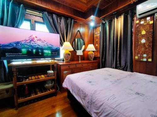 Ruenthip Homestay في بانكوك: غرفة نوم بسرير وتلفزيون بشاشة مسطحة