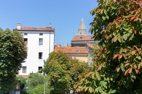 a white building with a tower in the background at CasamargheRita in Muggia