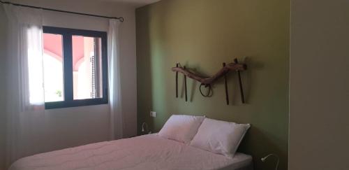 1 dormitorio con 1 cama con una rama en la pared en Holiday home HDA Golf Resort - HK 0011 B - Villa con picina privada, en Fuente Alamo
