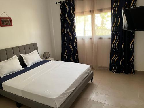 um quarto com uma cama grande e uma janela em Residence B&B Hibiscus em Dakar