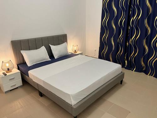 a bedroom with a large bed with two night stands at Residence B&B Hibiscus in Dakar