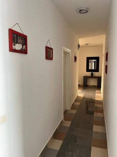 a hallway with white walls and a checkered floor at Residence B&B Hibiscus in Dakar