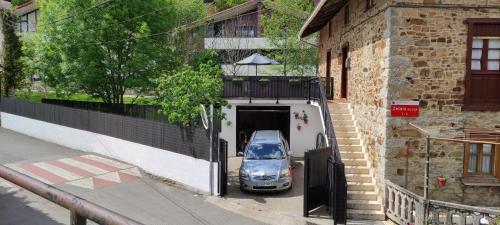 une voiture garée dans un garage à côté d'un bâtiment dans l'établissement Great place, rural environment, à Aránzazu Celaya